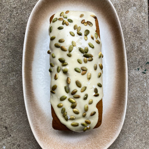 loaf of pumpkin cake on decorative platter on cement